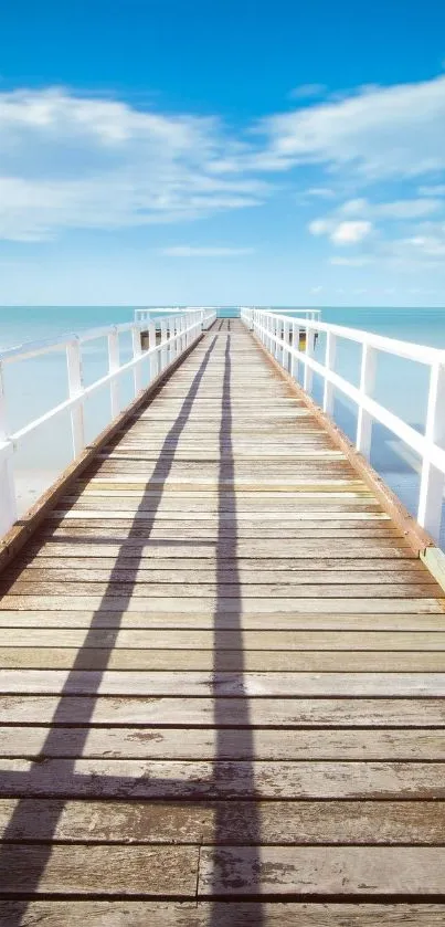 Serene ocean pier with blue skies and calm seas, perfect for mobile wallpaper.