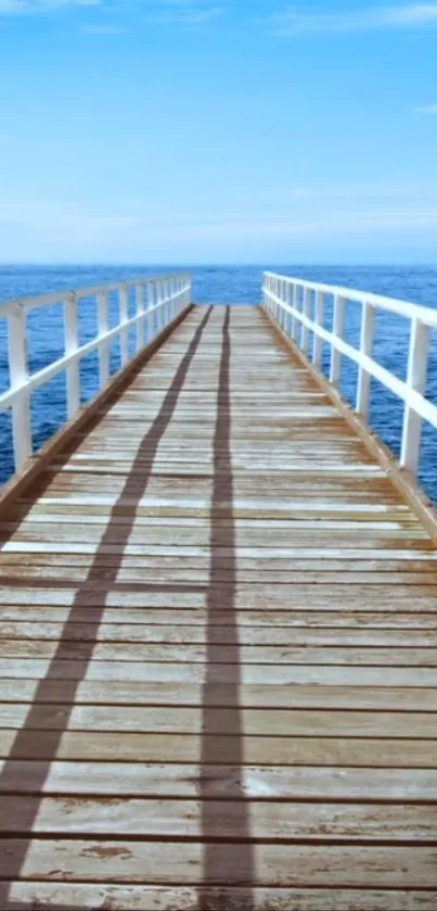 Serene ocean pier with blue sky and wooden boardwalk leading into the sea.