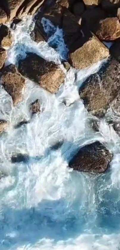 Aerial view of ocean waves crashing over rugged rocks.