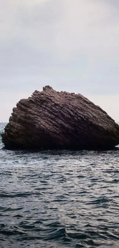 Solitary rock surrounded by ocean waves.