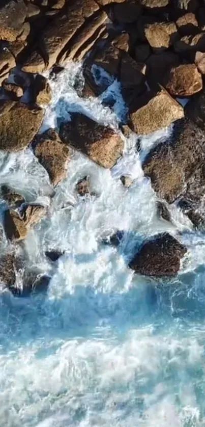 Aerial view of ocean waves crashing against rocky shore, creating a serene scene.