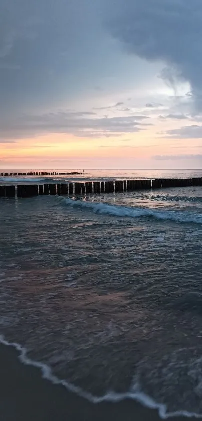 Serene ocean sunset with calm waves and pastel sky.