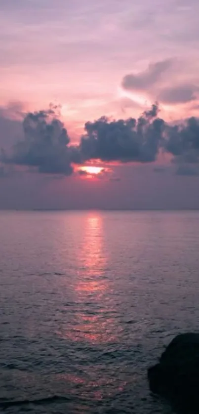 Serene sunset over calm ocean waters with vibrant pink and purple sky.