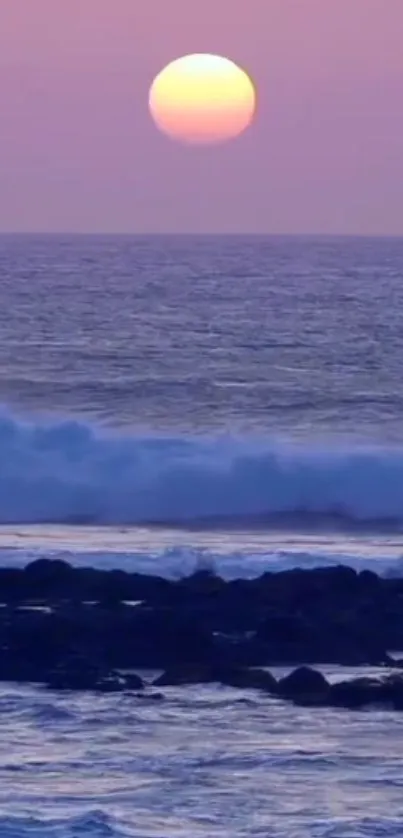 Serene ocean sunset with pink sky and gentle waves.