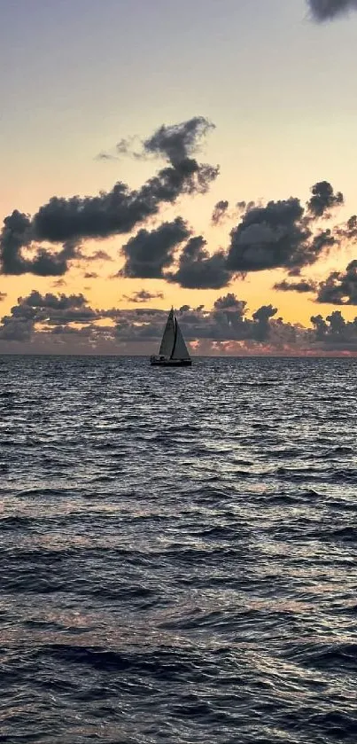 Solitary sailboat at sunset on a calm ocean.