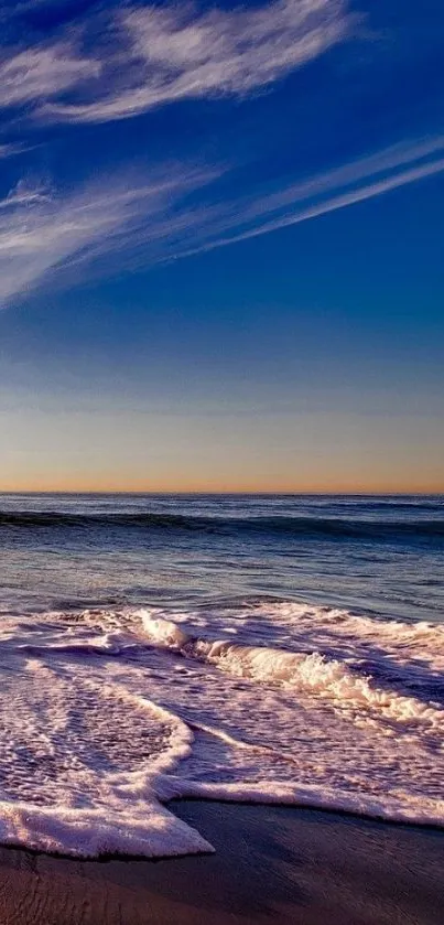 Serene ocean sunset with tranquil waves and blue sky.