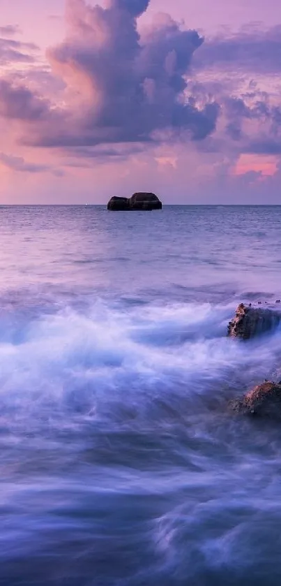 Purple sunset over ocean waves and rocks.