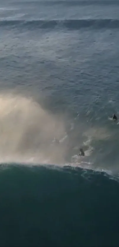 Aerial view of surfers riding a wave in a tranquil ocean setting.