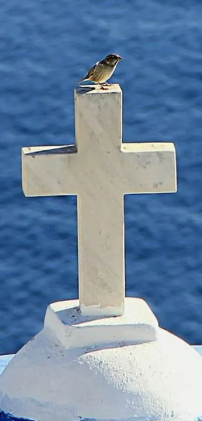 White cross with bird on vibrant blue ocean background.