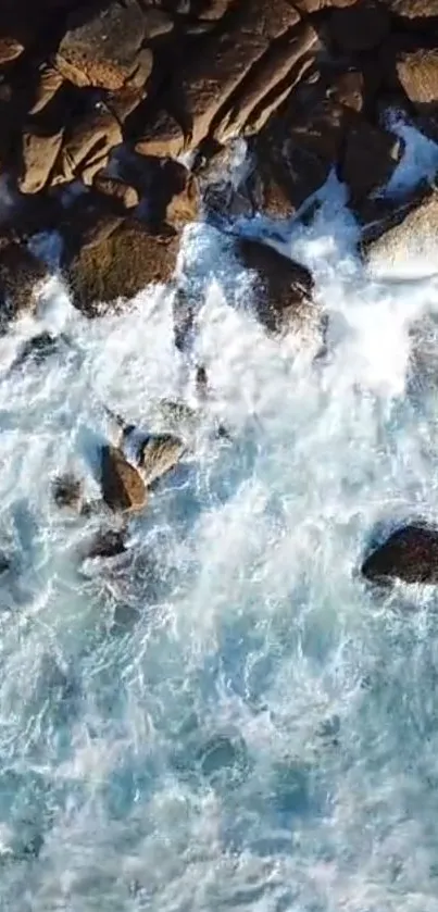 Aerial view of waves crashing on rocky coast with blue ocean.