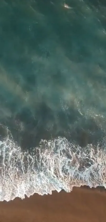 Aerial view of ocean waves meeting a sandy beach.