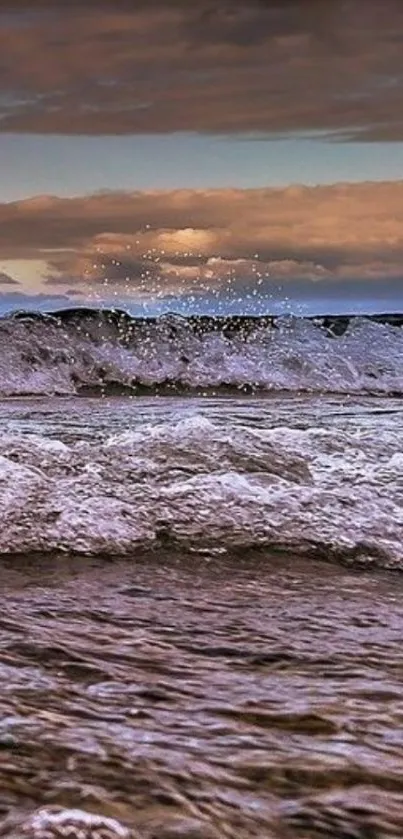 Majestic ocean waves under a moody sky at sunset.