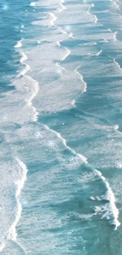 Turquoise ocean waves crashing peacefully onto the sandy shore.