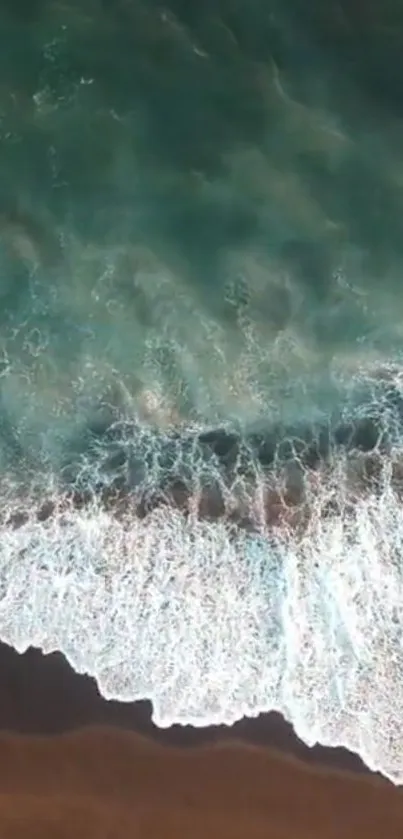 Aerial view of ocean waves gently crashing on the sandy beach for a calming background.