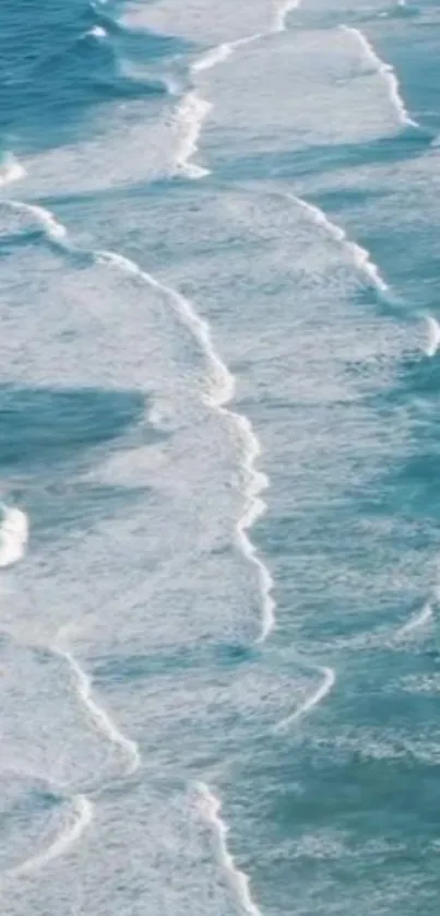 Aerial view of serene blue ocean waves with white foam.