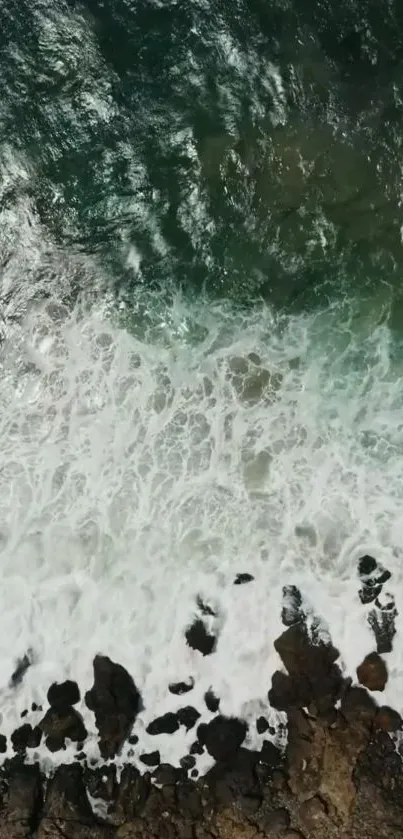 Aerial view of ocean waves crashing on a rocky shore for mobile wallpaper.