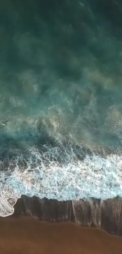 Aerial view of turquoise ocean waves meeting the sandy shore.