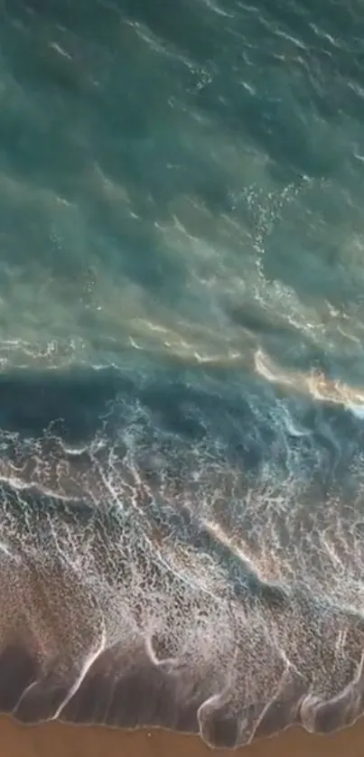 Aerial view of ocean waves meeting the sandy beach.