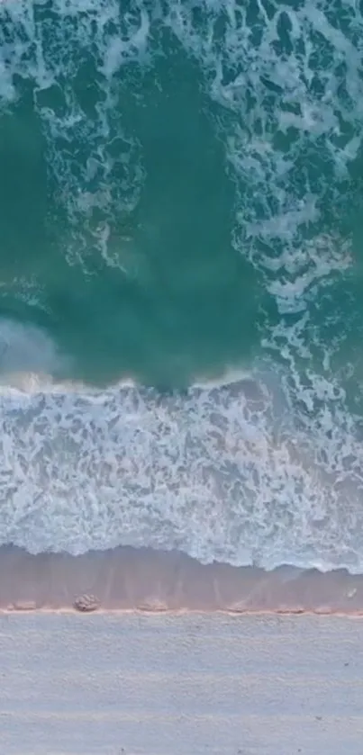 Aerial view of serene ocean waves hitting the shore with aqua blue water and white foam.