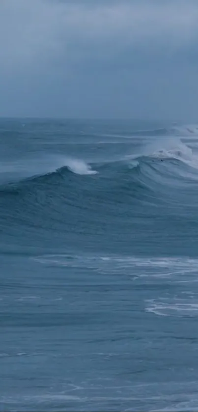 Serene ocean waves with calming blue hues and white foam under a cloudy sky.