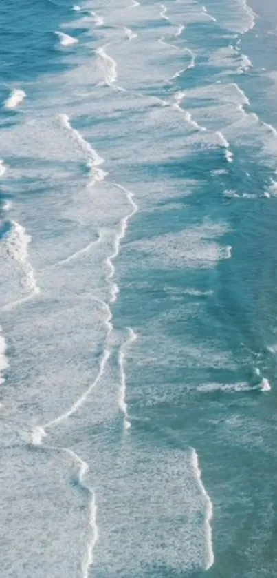 Aerial view of serene ocean waves crashing on a beach.