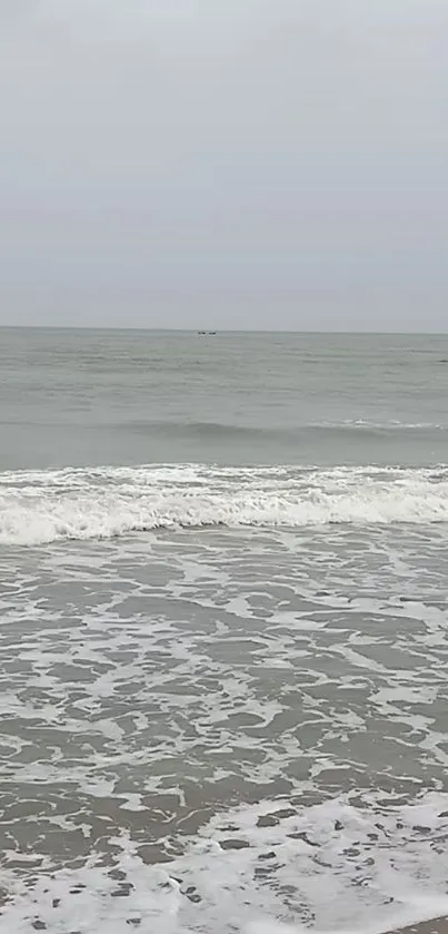 Calm ocean scene with gentle waves and a cloudy sky.