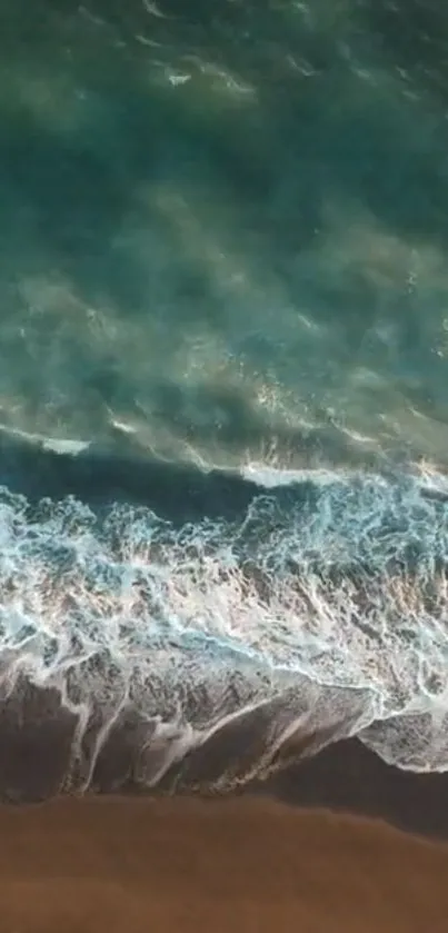 Aerial view of ocean waves meeting sandy shore.