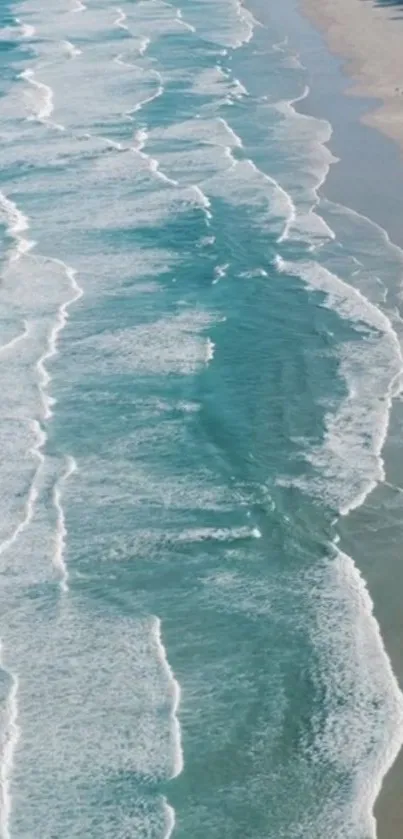 Aerial view of serene turquoise ocean waves crashing gently on a sandy beach.