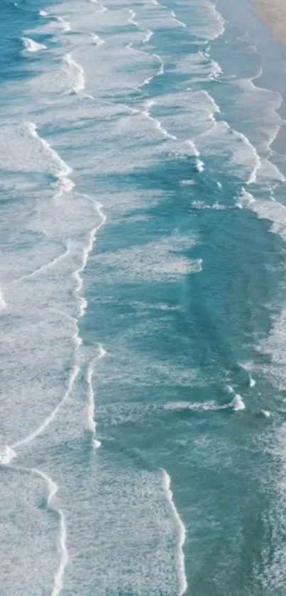 Aerial view of ocean waves meeting sandy beach.