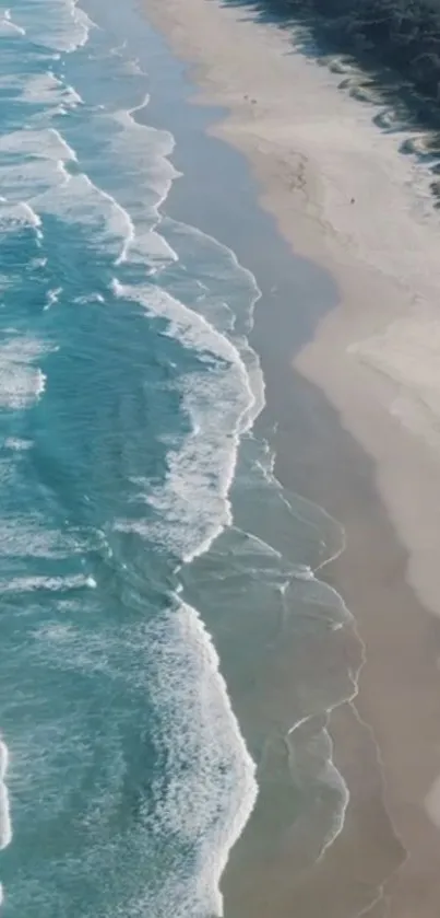 Aerial view of serene ocean waves along a sandy beach.