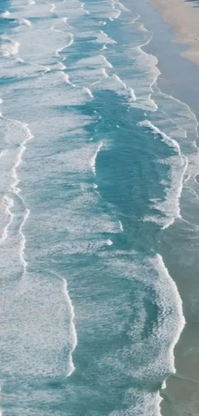 Aerial view of serene ocean waves crashing onto a sandy beach.