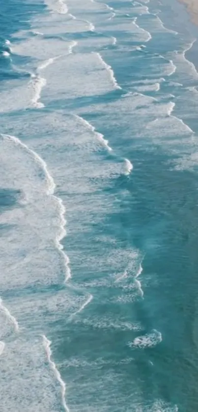 Aerial view of calming ocean waves on sandy beach.