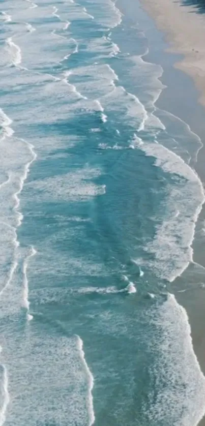 Aerial view of serene ocean waves and sandy beach.