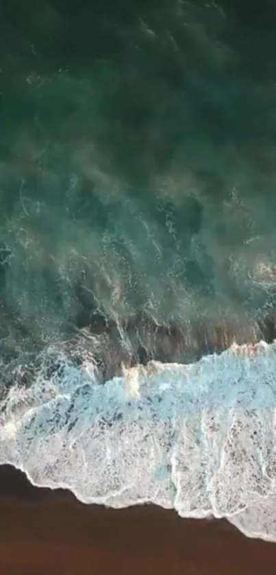 Aerial view of serene ocean waves crashing against the beach.