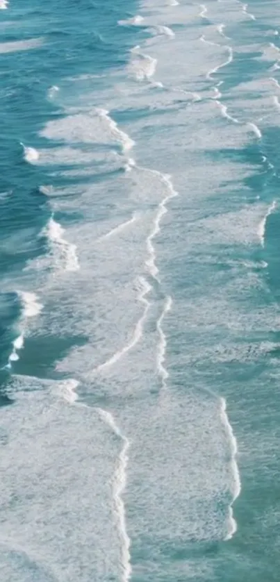 Aerial view of turquoise ocean waves and white foam for mobile wallpaper.