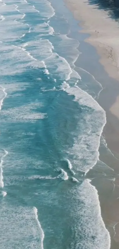 Aerial view of blue ocean waves and sandy beach.