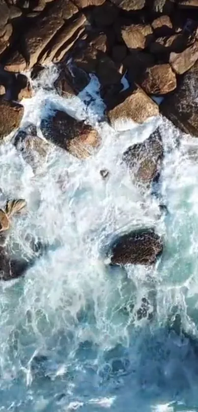 Aerial view of waves crashing on rocky shore, perfect for mobile wallpaper.