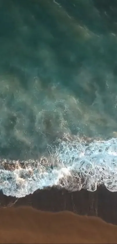 Aerial view of serene ocean waves crashing on a sandy beach with azure waters.