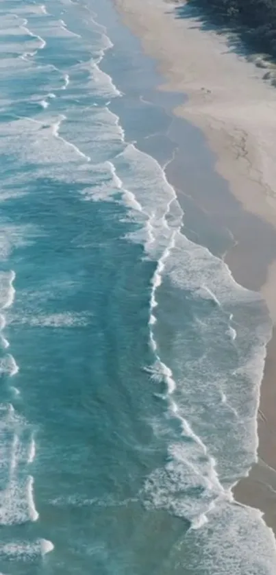 Aerial view of serene ocean waves meeting a sandy beach.