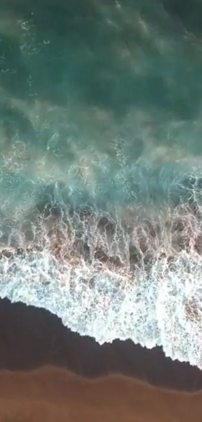 Aerial view of peaceful ocean waves crashing on a sandy beach.