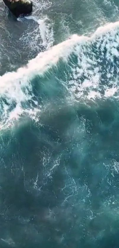 Aerial view of ocean waves hitting rocky shore.