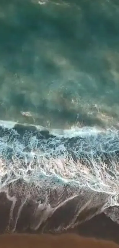 Aerial view of calm ocean waves on a sandy beach backdrop.