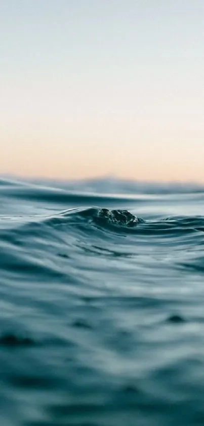 Serene ocean waves under a calm sky at sunset.