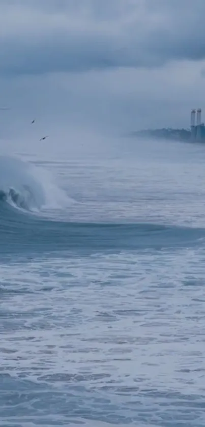 Ocean waves with a cloudy blue sky in the background, creating a serene atmosphere.