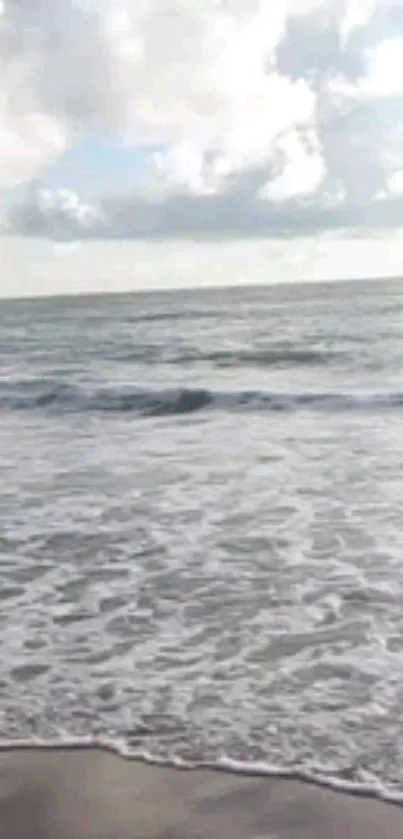 Calming ocean waves with a cloudy sky over the horizon.