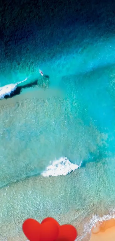 Aerial view of serene ocean waves with sandy beach and vibrant blue water.