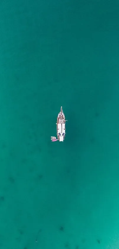 Aerial view of a yacht in the serene teal ocean, radiating tranquility.