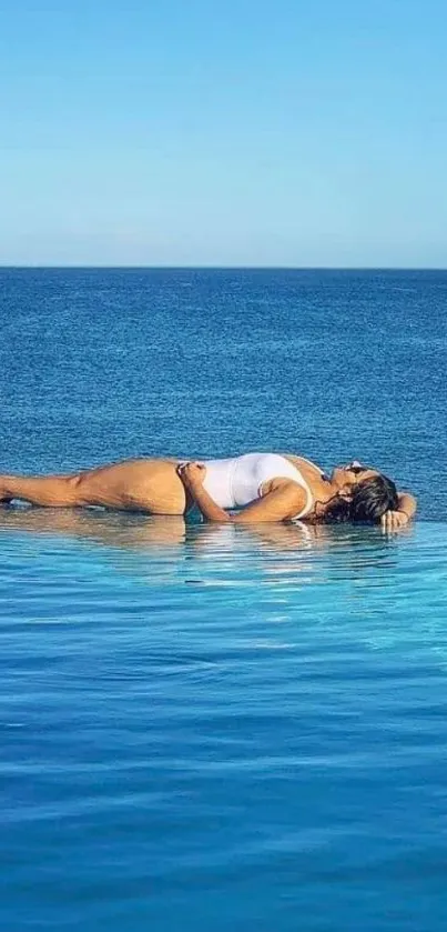 Woman relaxing by infinity pool with ocean view.