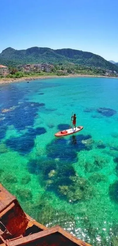 Serene paddleboard scene on turquoise water with lush hills.