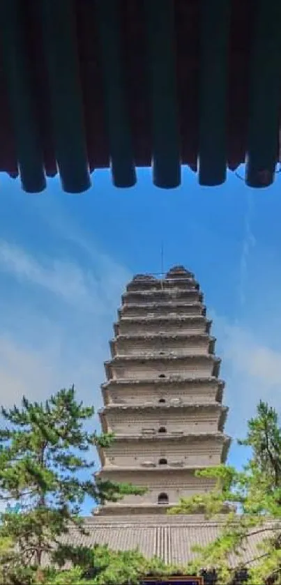 Serene pagoda framed by ornate wooden structures under a clear blue sky.